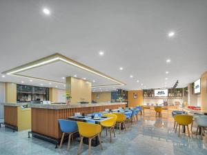 a restaurant with tables and chairs and a bar at Campanile NanChang MengShiDai XieJiaCun Metro Station in Nanchang