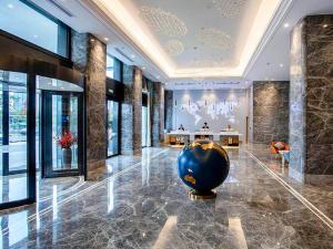 a lobby with a large vase on the floor of a building at Kyriad Marvelous Hotel Fujian Xiapu Railway Station in Xiapu
