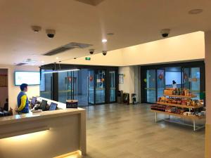 a man standing at a counter in a store at 7Days Inn Chongqing Longtou Temple North Train Station North Plaza Branch in Chongqing