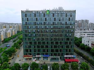 a tall building with a sign on top of it at JinJiang Inn Fashion Zhenjiang Dagang Pingchang Road in Zhenjiang