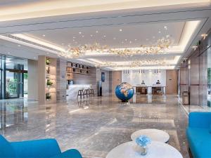 a lobby with a large ball in the middle of a room at Kyriad Hotel Zhongshan University of Science and Technology in Zhongshan