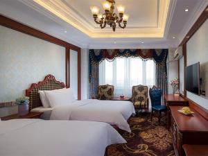 a hotel room with two beds and a television at Vienna Classic Hotel Manzhouli Zhongsu Street in Manzhouli