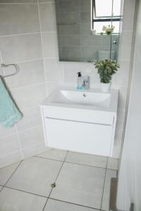 a white bathroom with a sink and a shower at 396 The Blyde Crystal Clear Lagoon 2 Bedroom Penthouse Apartment in Pretoria