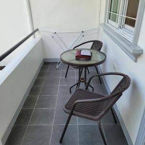 uma pequena mesa e duas cadeiras num quarto com escadas em TuloMir #A 뚤로미르 행복한 4인실 em Moalboal
