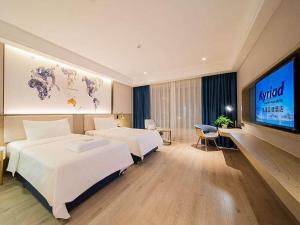 Postel nebo postele na pokoji v ubytování Kyriad Marvelous Hotel Heyuan Hakka Culture Park