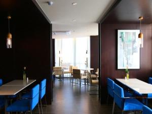une salle à manger avec des chaises et des tables bleues dans un restaurant dans l'établissement Jinjiang Inn Yangzhou Gaoyou East Haichao Road, à Gaoyou