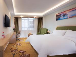 Pokój hotelowy z dużym białym łóżkiem i biurkiem w obiekcie Vienna SanHao Hotels Yichun Gao'an Avenue w mieście Gao'an