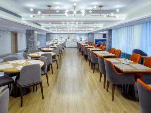 XiapuにあるKyriad Marvelous Hotel Fujian Xiapu Railway Stationのレストラン内のダイニングルーム(テーブル、椅子付)