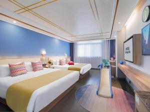 a hotel room with two beds and a tv at Campanile Yangzhou China Grand Canal & Ho Family Garden in Yangzhou