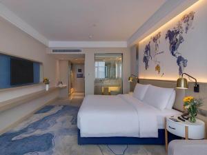 a hotel room with a large bed and a tv at Kyriad Marvelous Hotel Hengyang Changning in Changning