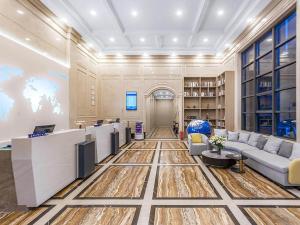 ein Büro mit einer Lobby mit einem Sofa und einem Schreibtisch in der Unterkunft Kyriad Hotel Jiujiang Happy City in Jiujiang