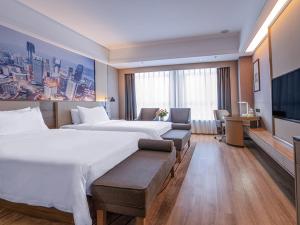 a hotel room with two beds and a flat screen tv at Vienna International Hotel Chongqing Ranjiaba in Chongqing