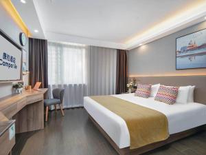 a hotel room with a large bed and a television at Campanile Yangzhou China Grand Canal & Ho Family Garden in Yangzhou