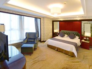 um quarto de hotel com uma cama e uma cadeira em Vienna International Hotel Yangzhou Wanda Lippo Plaza em Yangzhou