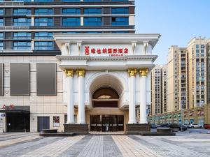 un bâtiment avec une arche au milieu d'une ville dans l'établissement Vienna International Hotel Wuxi Huishan Yanqiao Metro Station, à Wuxi