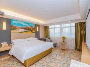 una camera con un grande letto e una grande finestra di Vienna Hotel Yichun Administration Center store a Yichun
