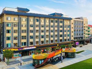 a large building with a shopping center in front of it at Kyriad Marvelous Hotel Weihai Happy Gate Weigao Plaza in Weihai