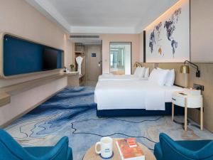a hotel room with a large bed and a flat screen tv at Kyriad Marvelous Hotel Shenzhen Longhua District Qinghu Subway Station in Tiantangwei