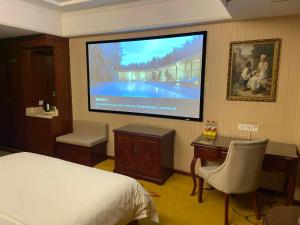 una camera con letto e TV a schermo piatto di Vienna Hotel Jiangsu Danyang Railway Station a Danyang