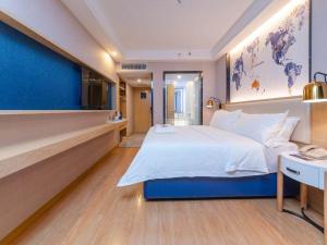 a hotel room with a large bed and a desk at Kyriad Marvelous Hotel Changsha Xiangya in Changsha