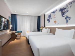 a hotel room with two beds and a map of the world at Kyriad Marvelous Hotel Shenzhen Baoan Gushu Metro Station in Bao'an