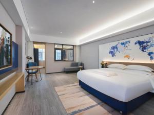 una camera da letto con un letto grande con una mappa sul muro di Kyriad Hotel Baoying Jinyuan Square High-speed Railway Station a Baoying