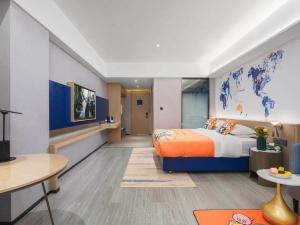 una camera d'albergo con un letto e una scrivania di Kyriad Hotel Baoying Jinyuan Square High-speed Railway Station a Baoying