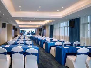 sala konferencyjna z niebieskimi stołami i białymi krzesłami w obiekcie Kyriad Marvelous Hotel Foshan Nanzhuang Taobo Avenue w mieście Foshan
