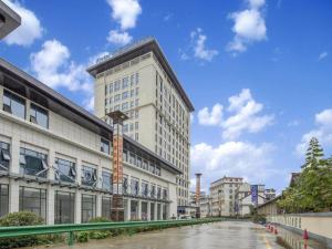 a large white building with a crane on the side of it at Kyriad Hanzhong Railway Station in Hanzhong