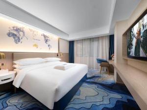 Una habitación de hotel con una cama grande y un televisor de pantalla plana. en Kyriad Marvelous Hotel Heyuan Longchuan, en Longchuan 9 fotos más
