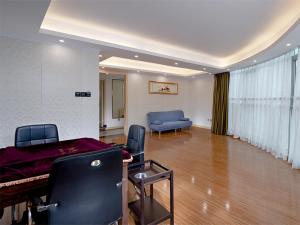 sala de estar con piano y sofá azul en Vienna Classic Hotel Shenzhen Pingshan Bihu Hotel, en Longgang