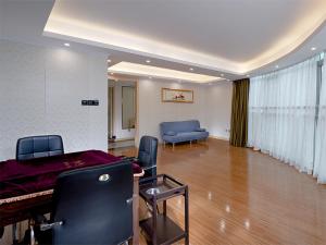 a living room with a piano and a blue couch at Vienna Classic Hotel Shenzhen Pingshan Bihu Hotel in Longgang