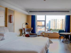 a hotel room with a bed and a large window at Vienna International Hotel Jiangsu Wuxi Jiangyin Sports Center in Jiangyin +36 photos