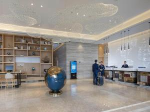 漢中的住宿－凯里亚德酒店(汉中高铁站店)，两个人站在图书馆里,拿着一个大蓝球