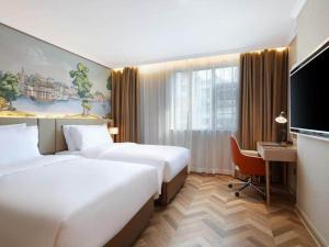 a hotel room with two beds and a desk at Vienna Hotel Changsha Yuelu Mountain University city Xihu Park in Changsha