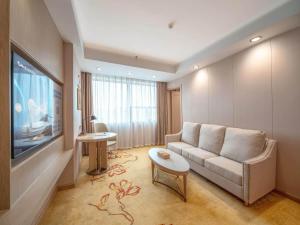a living room with a couch and a flat screen tv at Vienna Hotel Qingyuan City Square Lianjiang Road Hotel in Qingyuan