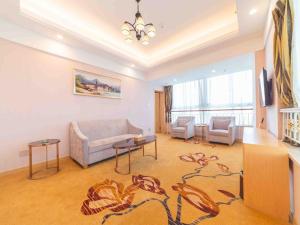 a living room with a couch and two chairs at Vienna International Hotel Nanjing Dongshan Headquarters in Yangzhou