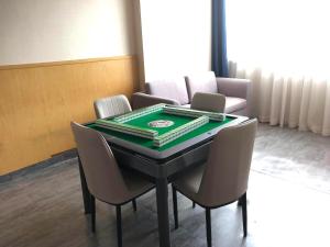 Zimmer mit einem Tisch mit Stühlen und einem Pokertisch in der Unterkunft Kyriad Marvelous Hotel Foshan New City Lecong Town in Shunde