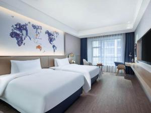 a hotel room with two beds and a map of the world at Kyriad Marvelous Hotel Guizhou Dujun Center Wanda Plaza in Duyun