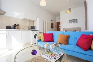 uma sala de estar com um sofá azul e almofadas vermelhas em -MalagaSunApts-Pop Dream CityCentre em Málaga