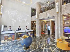 a lobby with a large blue globe on the floor at Kyriad Marvelous Hotel Harbin Railway Station Central Avenue in Harbin
