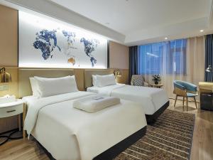 Dos camas en una habitación de hotel con un mapa del mundo en Kyriad Marvelous Hotel Suzhou Guanqian Street and Shiquan Street en Suzhou