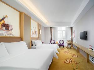 Cette chambre comprend 3 lits et une télévision. dans l'établissement Vienna International Hotel Mongolia Chifeng High-Speed Railway Station, à Chifeng