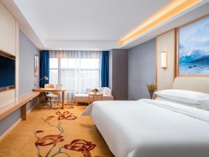 a hotel room with a large bed and a desk at Vienna Hotel Lukou Airport in Jurong