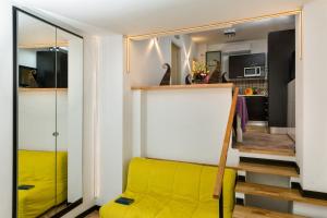 Sofá amarillo en la sala de estar con espejo en Giasone Apartments, en Taormina