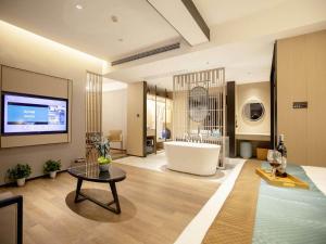 uma grande casa de banho com banheira e um quarto grande em Kyriad Marvelous Hotel Changsha Hunan Financial Center em Changsha
