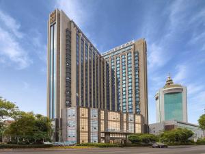 a large building with two tall buildings at Kyriad Jinjiang Hotel in Jinjiang