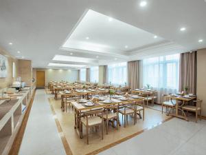 a large dining room with tables and chairs at Vienna International Hotel Taizhou Wenling Branch in Taizhou