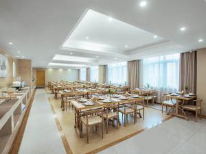 une grande salle à manger avec des tables et des chaises dans l'établissement Vienna International Hotel Taizhou Wenling Branch, à Taizhou