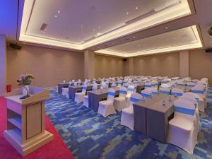 a large room with tables and chairs and a podium at Kyriad Marvelous Hotel Hengyang Changning in Changning